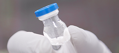 Gloved hand holding tube